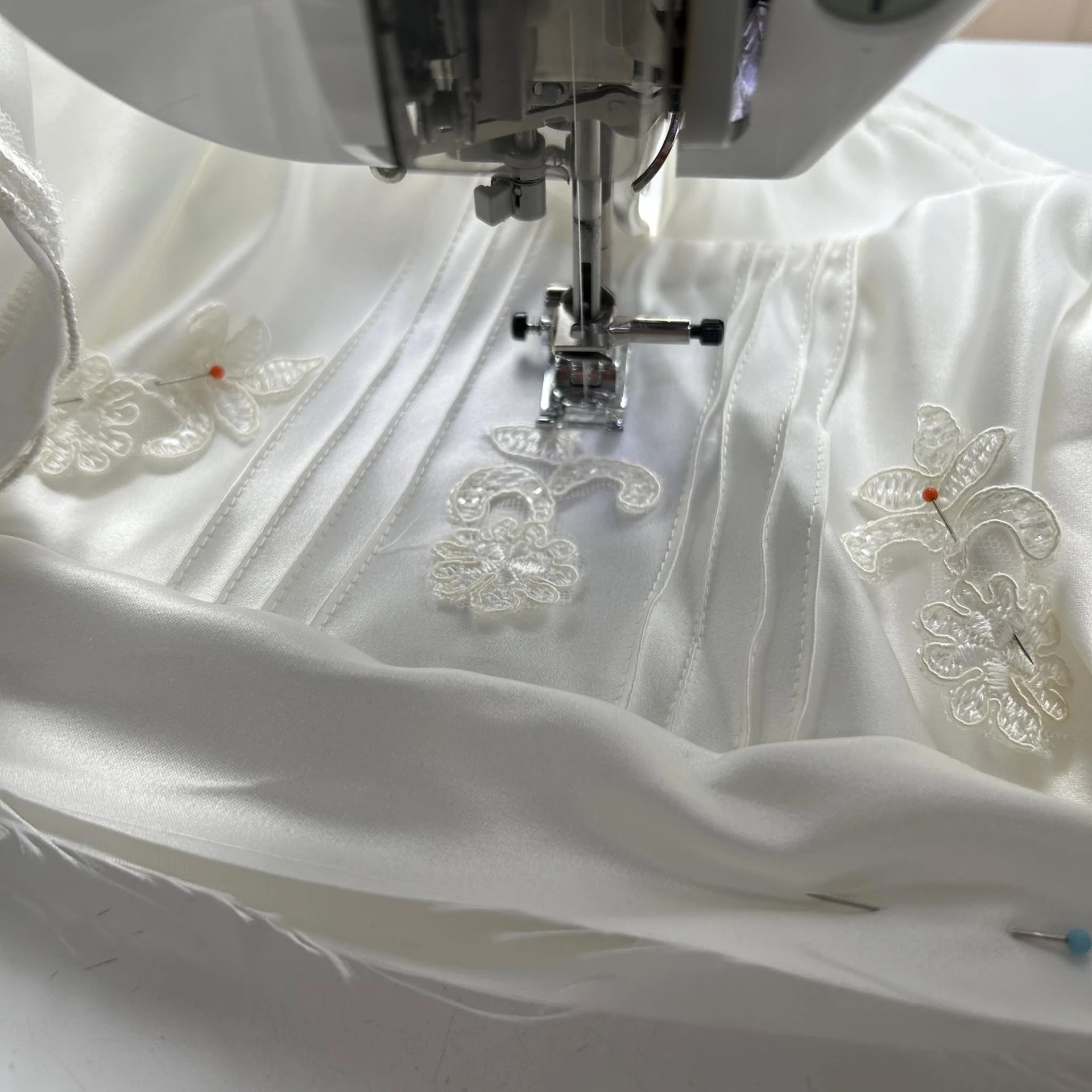 Bridal fabric being carefully sewn and embellished